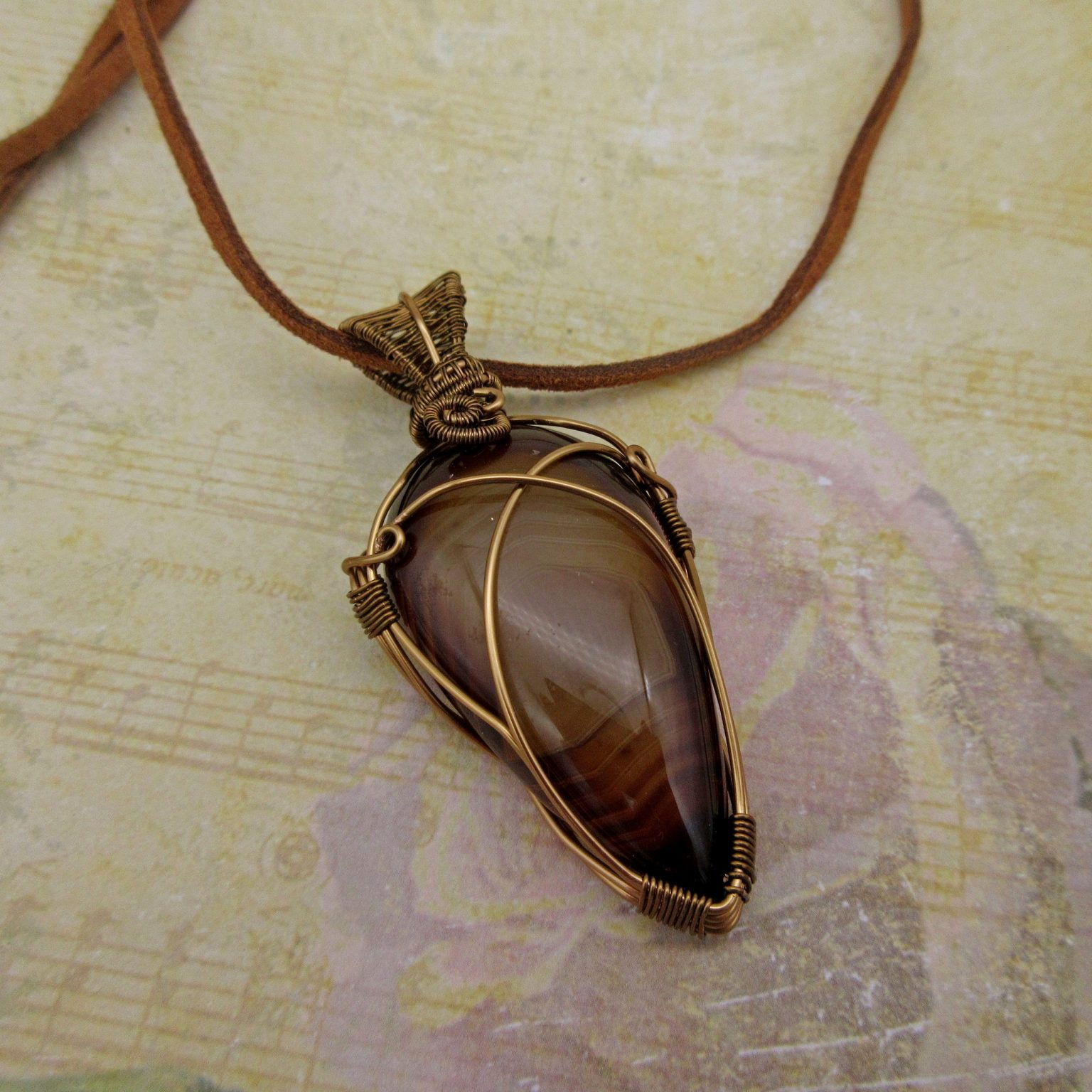 Wire-wrapped brown onyx pendant with leather cord.