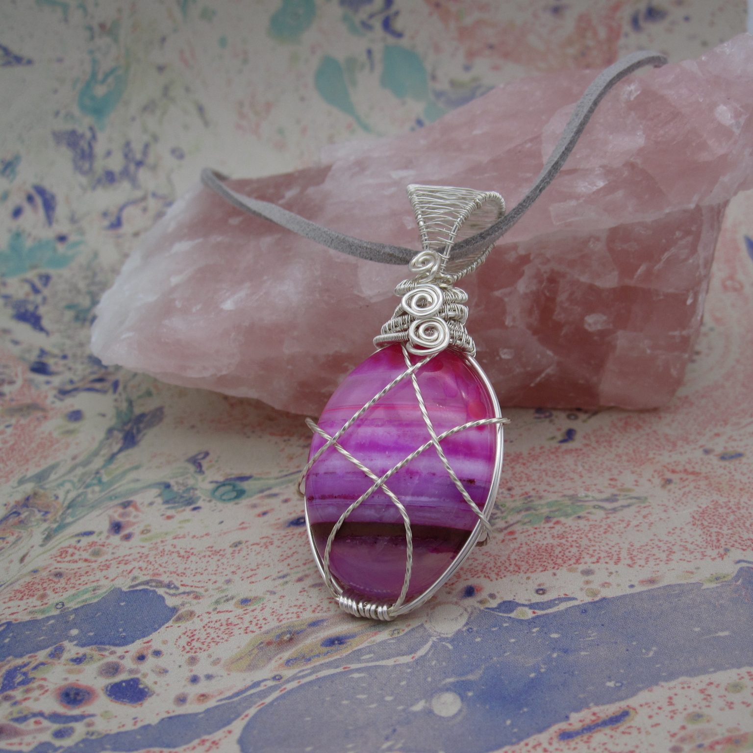 Silver plated wire-wrap pendant with pink agate and leather cord.